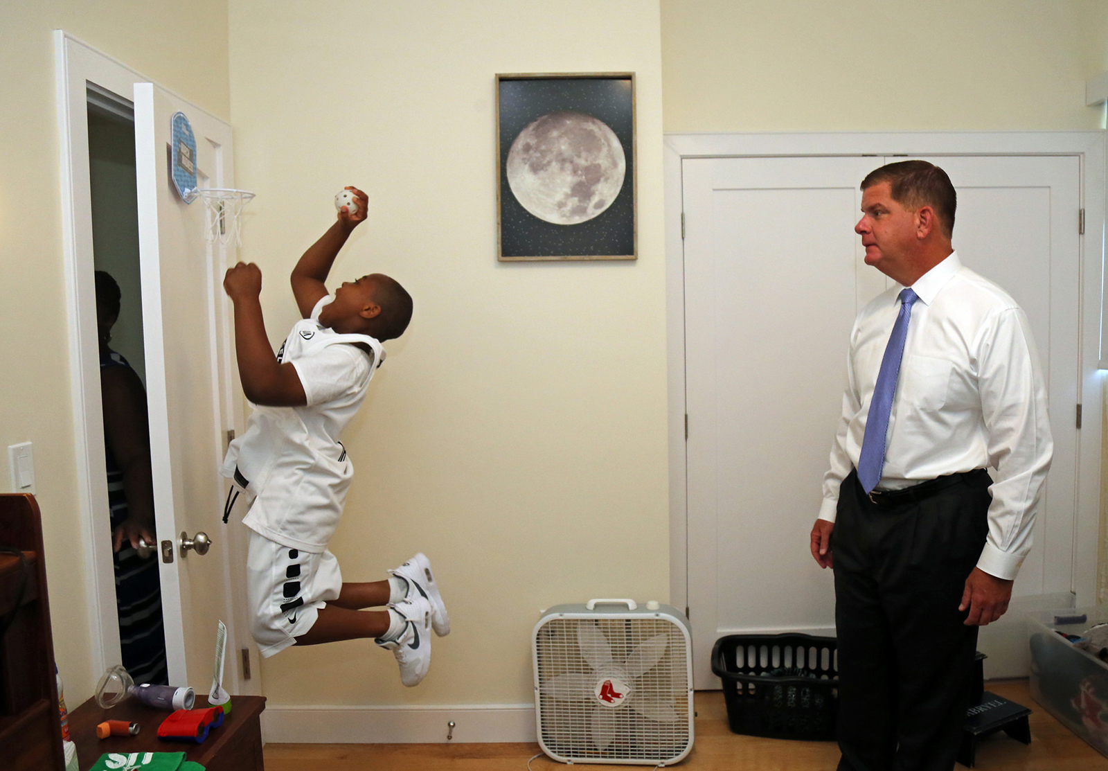 Image for mayor walsh watched 9 year old gabryel dunk as he showed off his new bedroom during the home buying celebration for patricia brown 