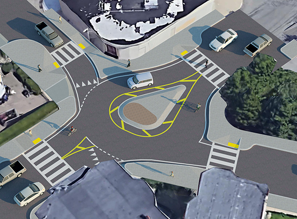 This aerial rendering shows a teardrop-shape center island and some larger curb extensions to form a roundabout in the intersection.