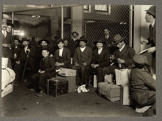 "A group of Italians in the railroad waiting room, Ellis Island, 1905" New York Public Library Digital Collections