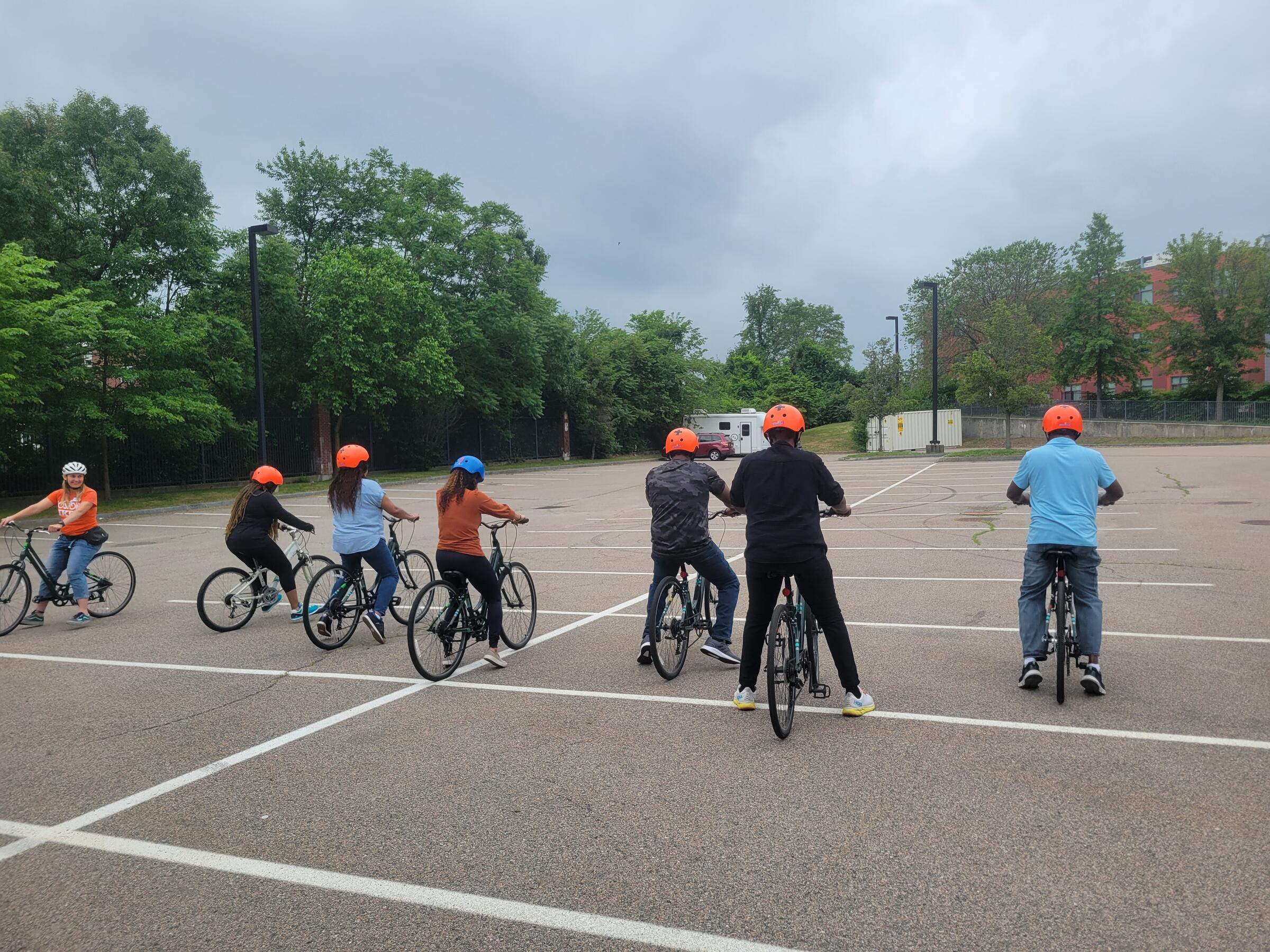 a group of adults learning how to ride a bicycle