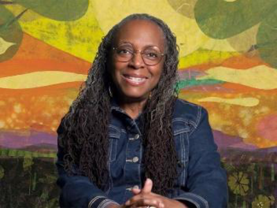 Image of a woman, Ekua Holmes, smiling with her hands held together