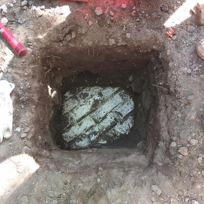 Plan view of an archaeological shovel test pit with a white tiled surface at the bottom.