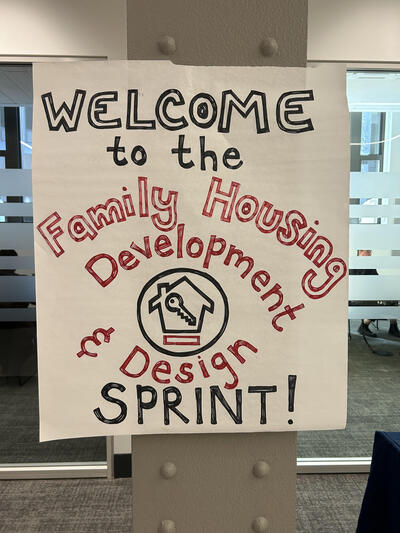 A handmade sign that says "Welcome to the Family Housing Design sprint"