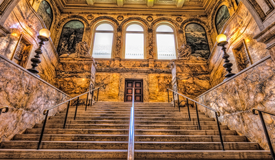 Image shows the hall of the Boston Public Library, looking up from the stairs.