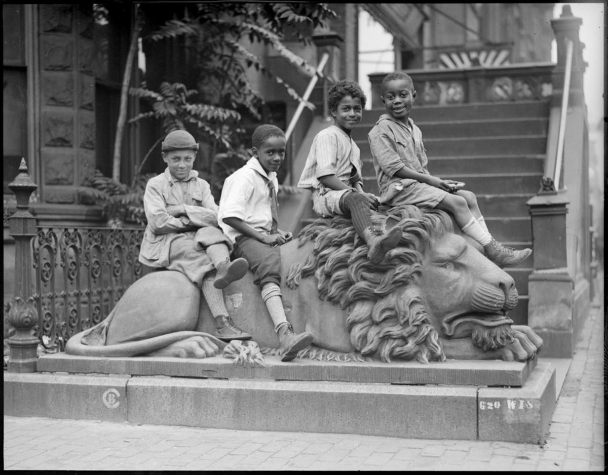 South End kids pose on stone lion, 511 Columbus Ave. 
