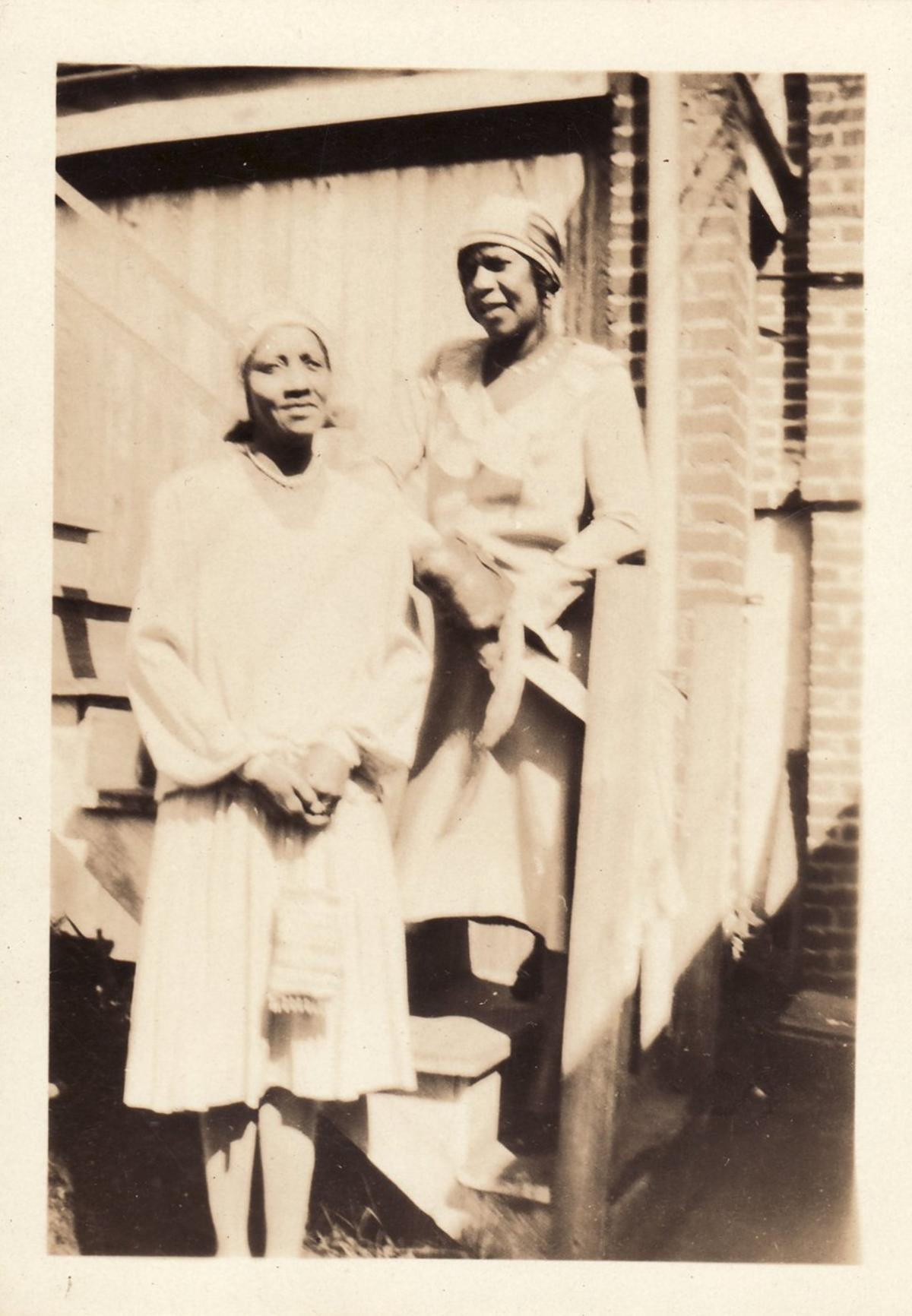 Two women pose on staircase