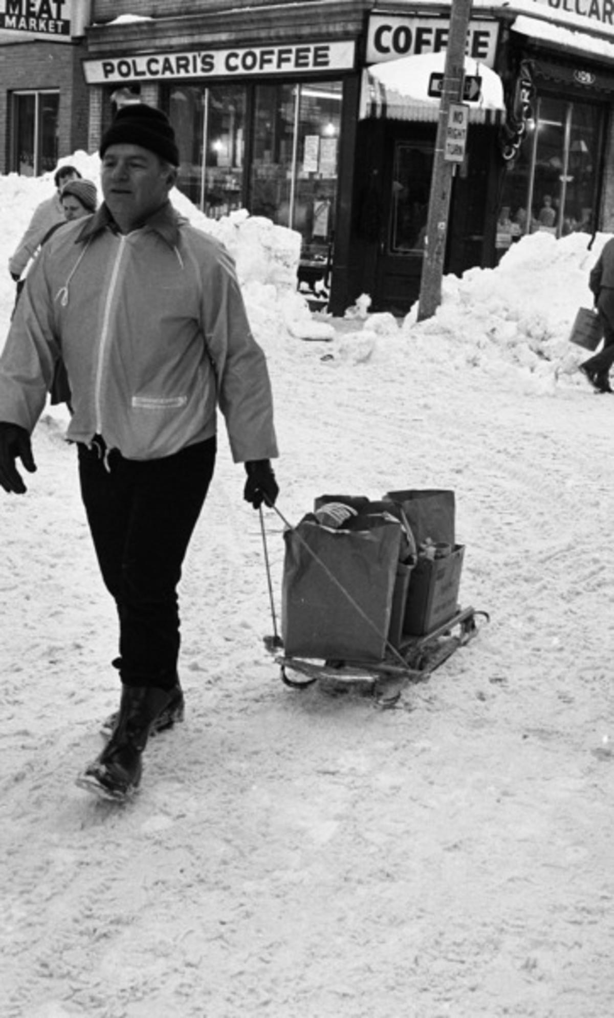 Unidentified volunteer pulling sled full of paper bags on Salem Street