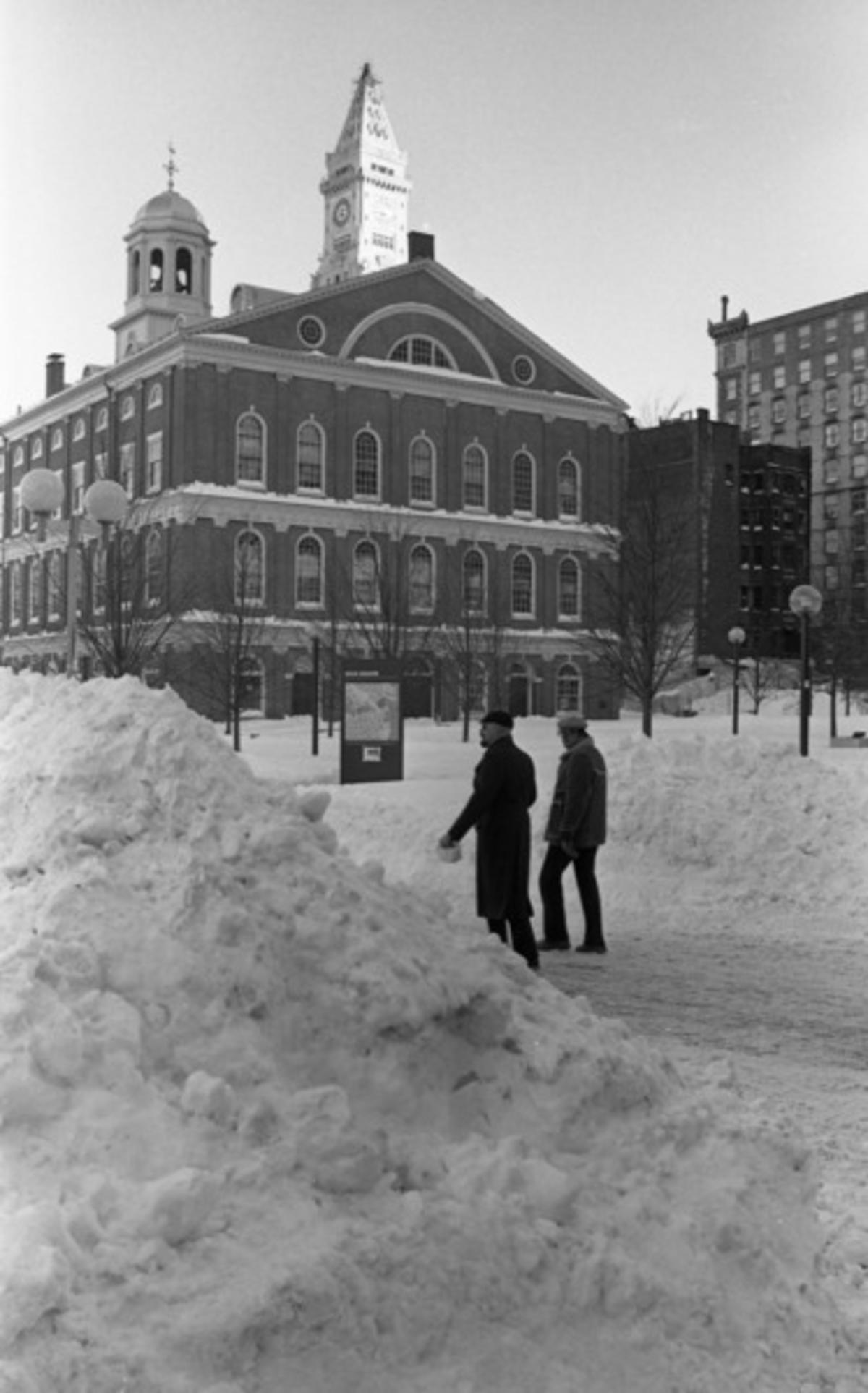 Snow piles and pedestrians in front of Faneuil Hall