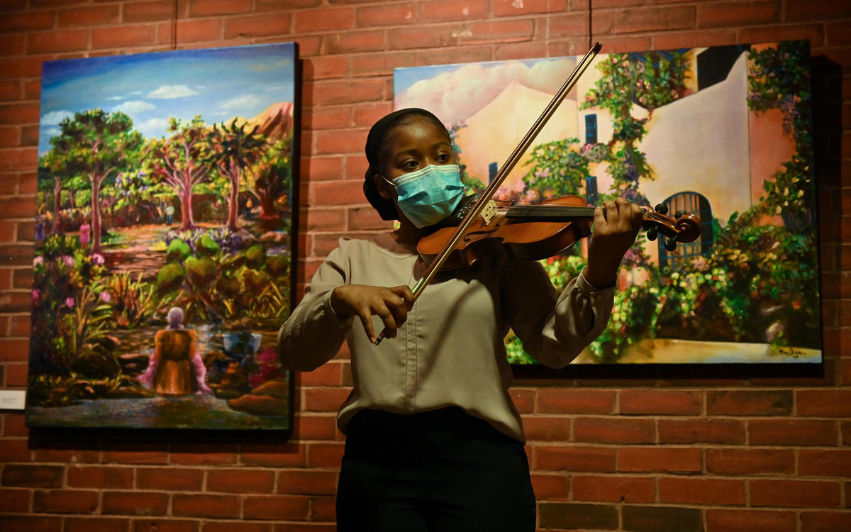 Young violinist plays in front of art in City Hall