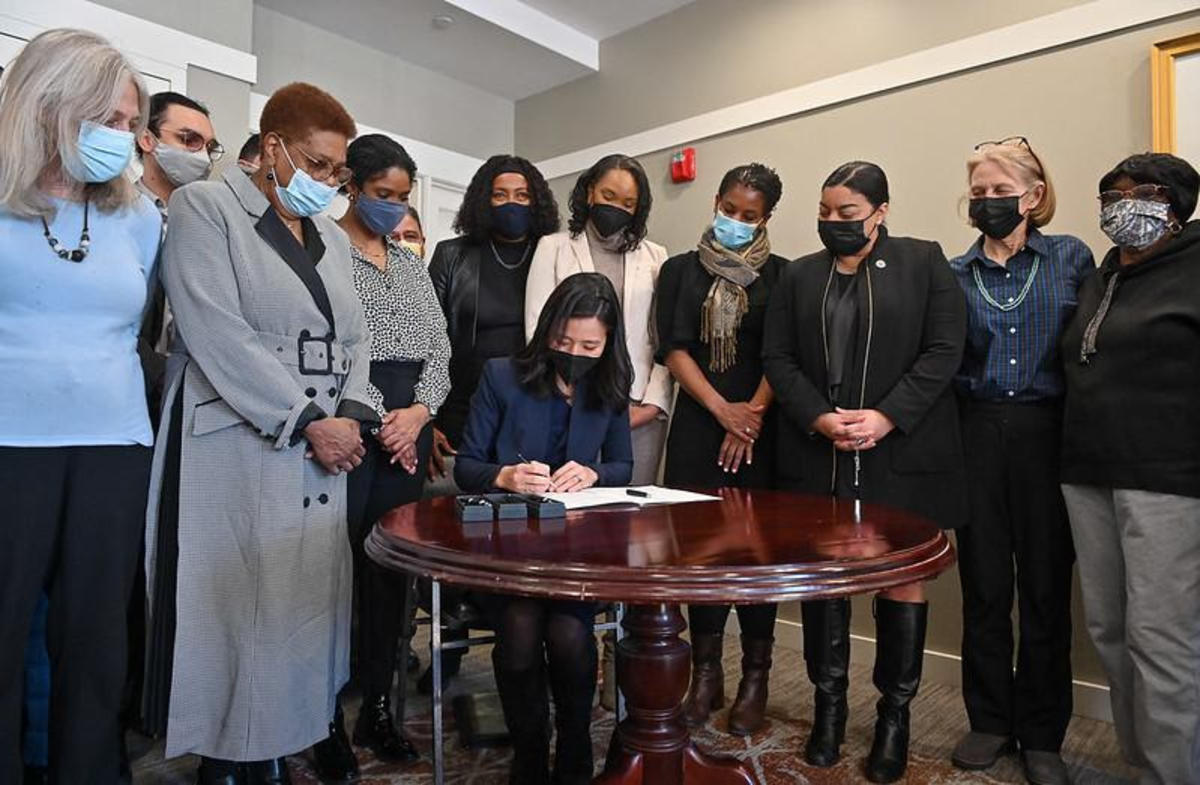 The Mayor, surrounded by elected officials and residents, signs a home rule petition to implement a transfer free on real estate sales.