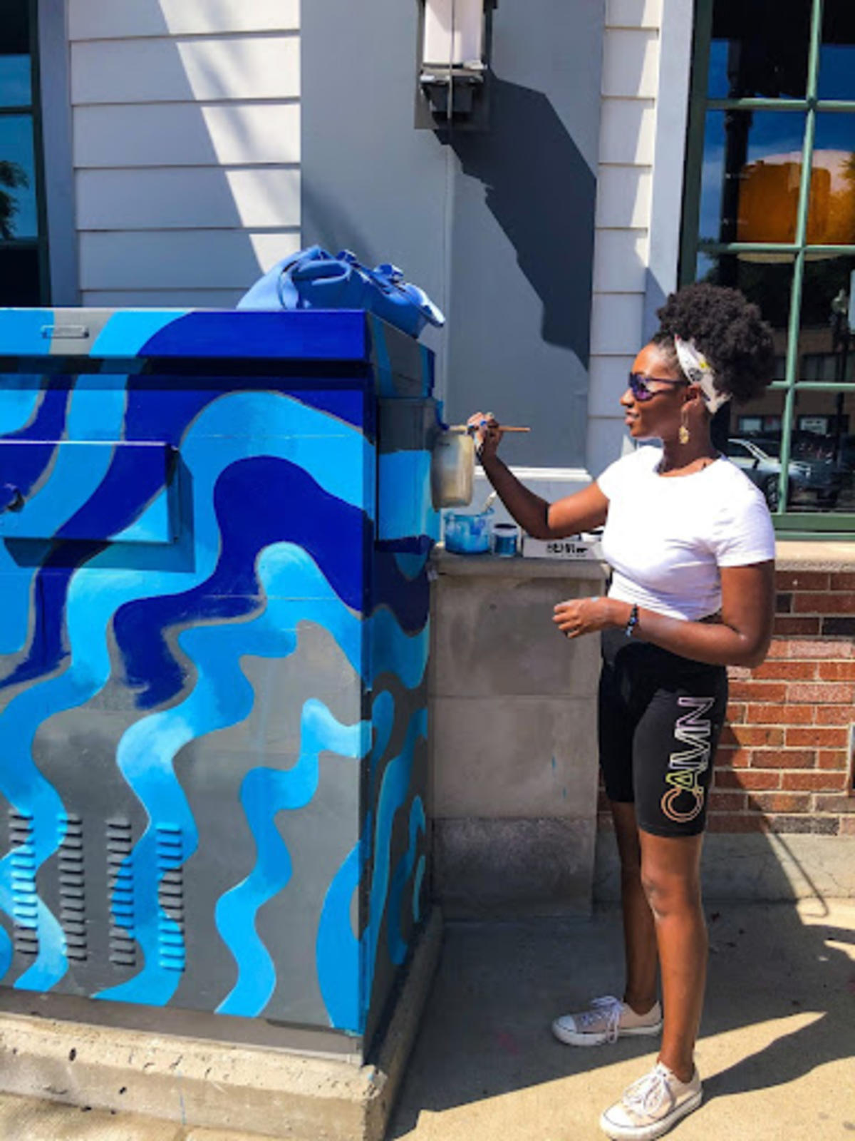 Artist Erica Imosi looking on at her Blue, wave designed PaintBox