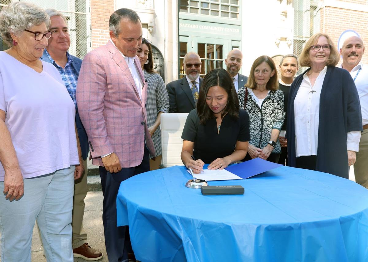 Mayor Wu signing the BCYF Nazzaro Community Center Landmark designation.