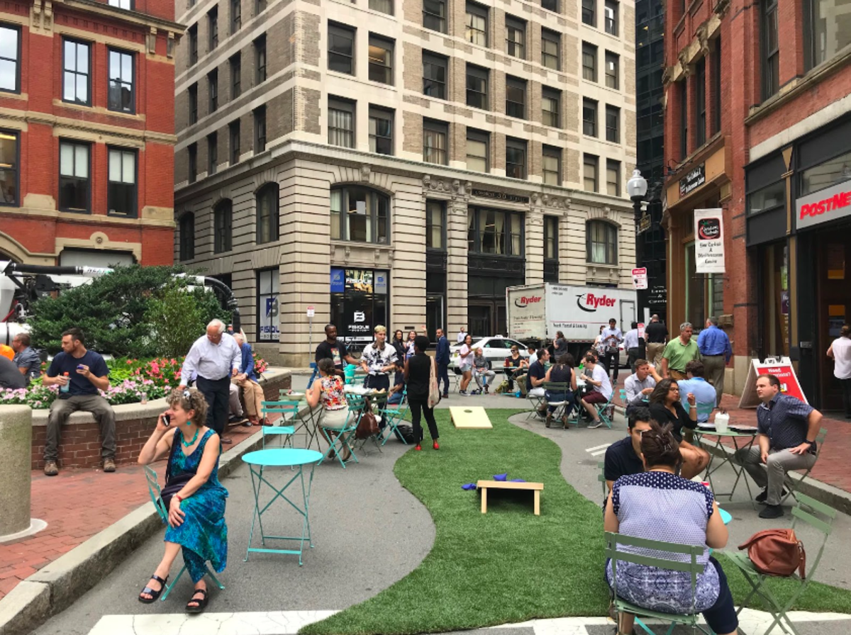 People enjoy a temporary pedestrian plaza in Liberty Square