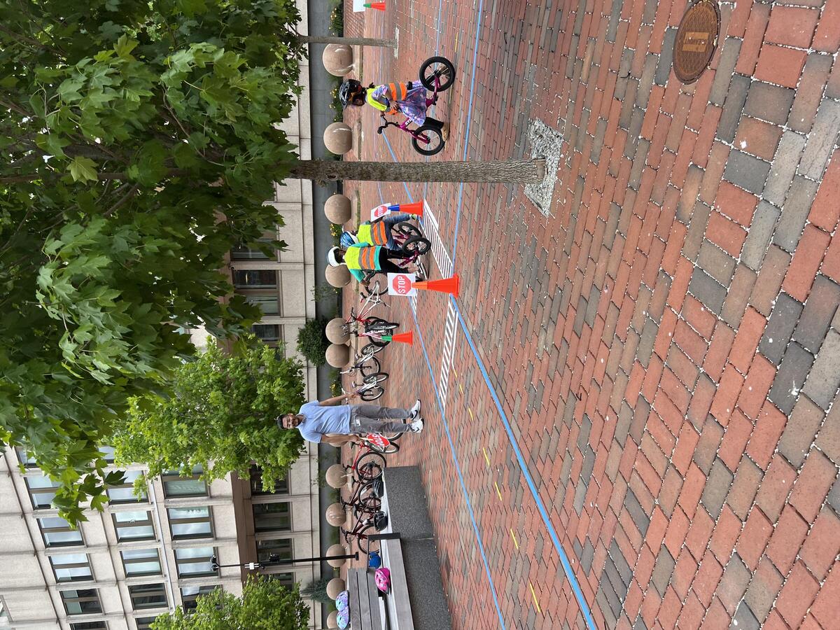 Young children riding bikes in the new City Hall Plaza bike town.