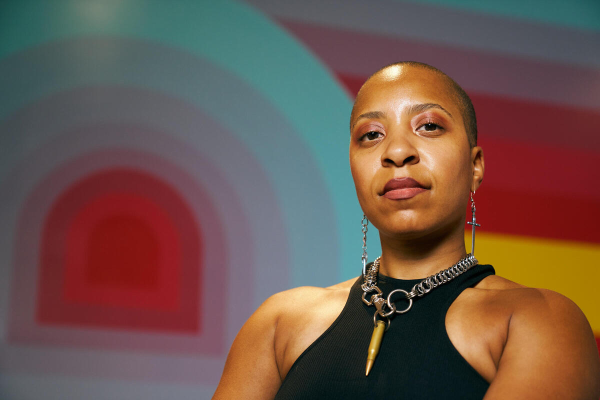 Headshot of Massiel Grullón standing in front of one of her completed murals