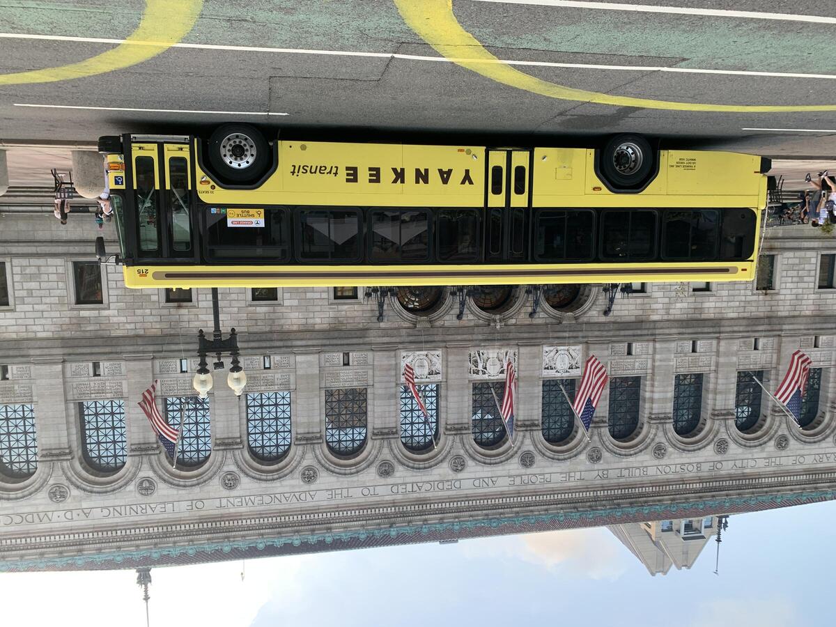 Yellow Shuttle Bus with sign in window reading "Orange Line Shuttle Bus" with MBTA and Accessible symbols
