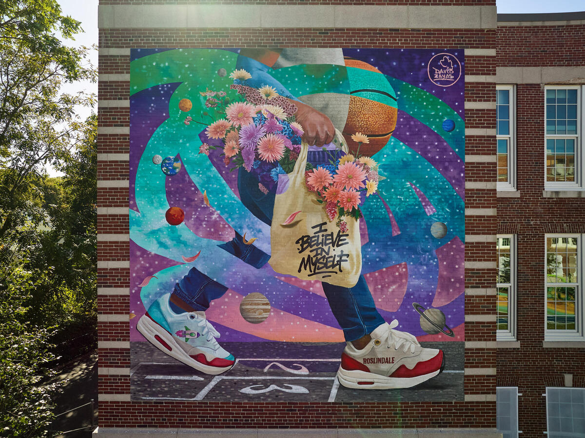 A young girl walking with a tote bag that says "I believe in myself"