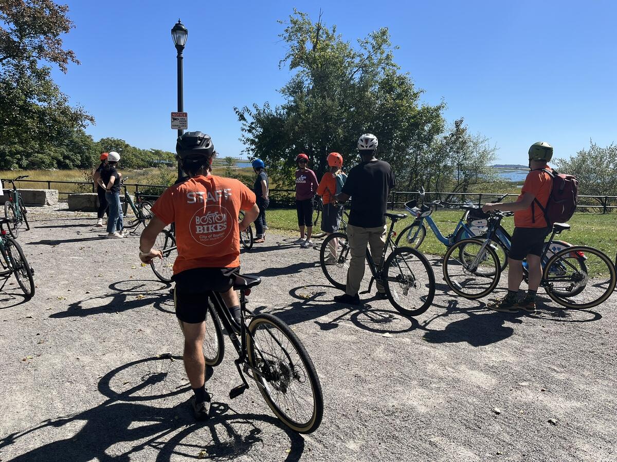 People preparing to ride their bikes gather on an off-street path during a learn-to-ride workshop in Boston