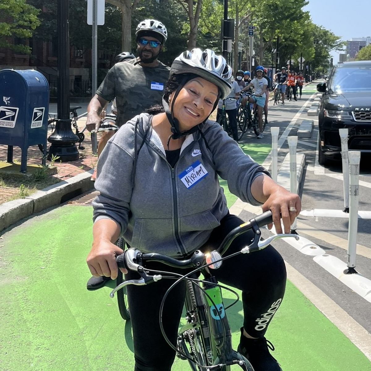A learn-to-ride workshop participant poses on her bike in a bike lane