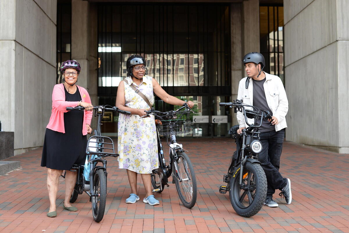 a photo of three residents with e-bikes