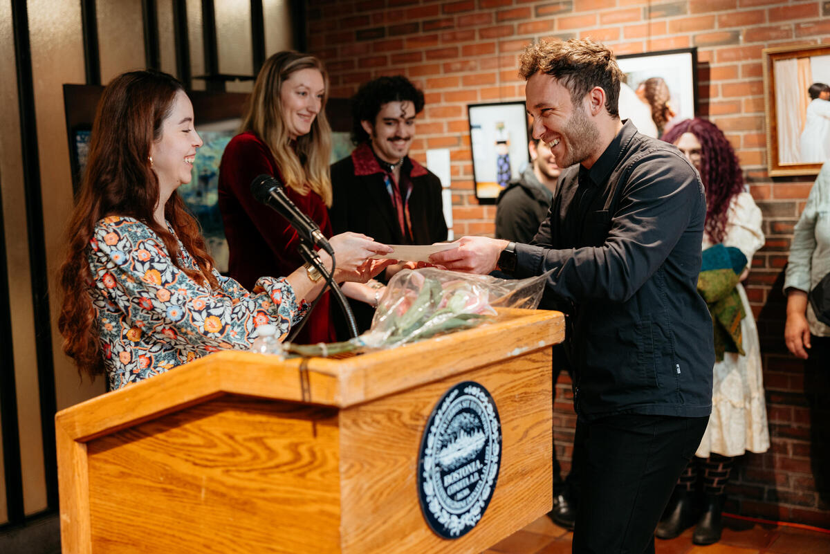 An artist receives an award at the 2024 Fay Chandler Emerging Art Exhibition reception