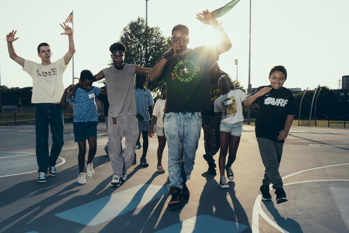 Children learning to dance on a basketball court in a City of Boston park