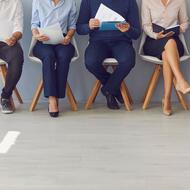 People sitting on chairs, seemingly waiting for a job interview