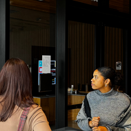 City workers look at a window, arranging sticky notes on a wall. They are developing a process map while participating in Bostonia Academy.