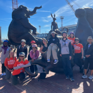 Everyone from the workshop poses near a big statue of an elephant after completing their Learn-to-Ride session