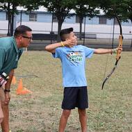 A young boy practicing archery.
