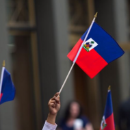Hand holding Haitian flag