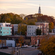 balcony view of dorchester and southies buildings with tall trees who have orange, green, dark red leaves