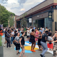 a photo showing a group of people dancing on a pedestrianized street