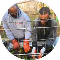 City of Boston employee helps a student plant a community garden